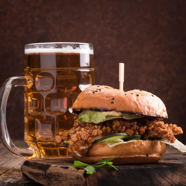 Vers en smakelijk hamburger met een biertje op een houten tafel. — Stockfoto