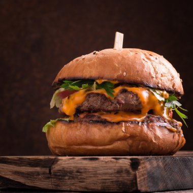 Lezzetli ızgara burger marul ve mayonez, rustik ahşap bir masa üzerinde