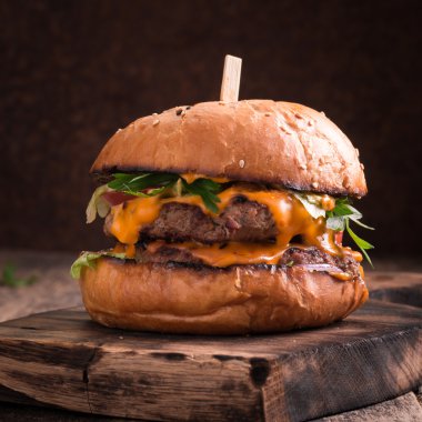 Lezzetli ızgara burger marul ve mayonez, rustik ahşap bir masa üzerinde