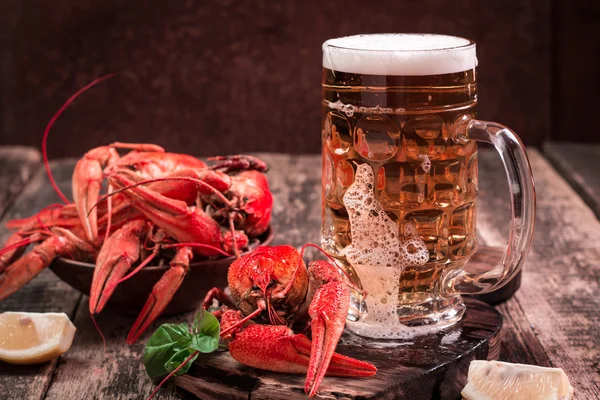 Langusta vařená a pivo na dřevěné pozadí — Stock fotografie