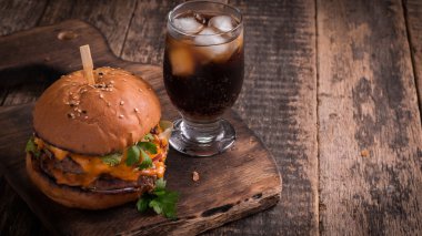 hamburger ya da çizburger ve meşrubat vintage ahşap masa üzerinde Fast food