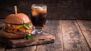 hamburger ya da çizburger ve meşrubat vintage ahşap masa üzerinde Fast food