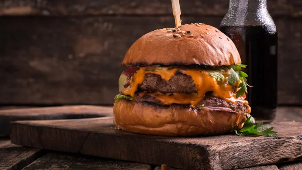 Comida rápida con hamburguesa o hamburguesa con queso, y refresco en la mesa de madera vintage — Foto de Stock