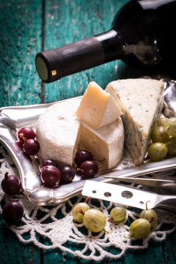 Kompozisyon peynir, çilek, şişe ve bardak şarap ahşap bir masa üzerinde 