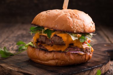 Lezzetli ızgara burger marul ve mayonez, rustik ahşap bir masa üzerinde