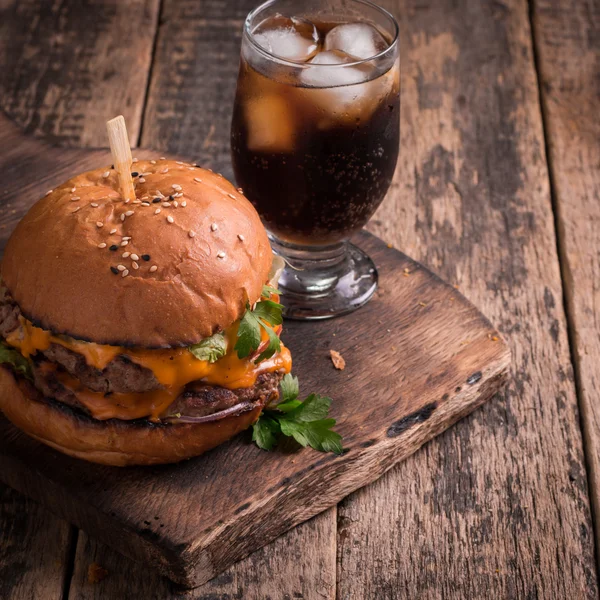 fast food with burger or cheeseburger, and soft drink on vintage wooden table