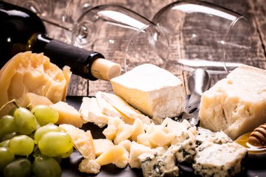 Kompozisyon peynir, çilek, şişe ve bardak şarap ahşap bir masa üzerinde 