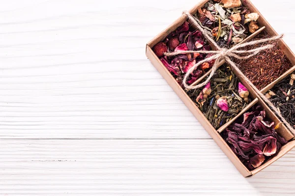 Surtido de té seco en una mesa de madera, bebida saludable — Foto de Stock