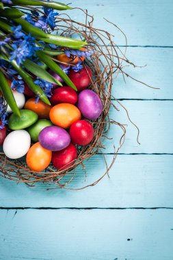 Ahşap arka plan üzerinde renkli yumurta Paskalya konseptiyle