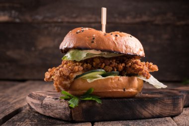 Lezzetli ızgara burger marul ve mayonez, rustik ahşap bir masa üzerinde