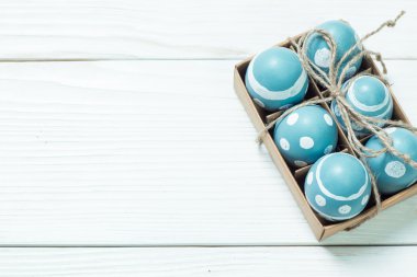 Ahşap arka plan üzerinde renkli yumurta Paskalya konseptiyle