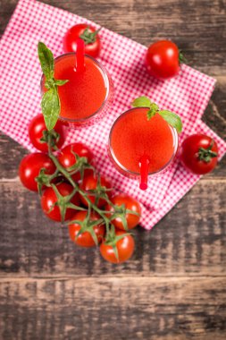 Domates suyu ve ahşap arka plan üzerinde taze domates