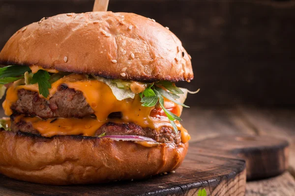 Sabrosa hamburguesa a la parrilla con lechuga y mayonesa, sobre una mesa de madera rústica — Foto de Stock