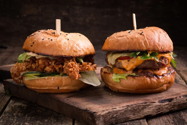 Leckere gegrillte Burger mit Salat und Mayonnaise, auf einem rustikalen Holztisch — Stockfoto