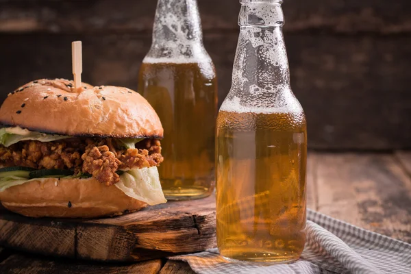 Vers en smakelijk hamburger met een biertje op een houten tafel. — Stockfoto