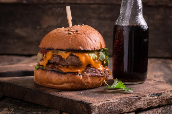 Comida rápida con hamburguesa o hamburguesa con queso, y refresco en la mesa de madera vintage — Foto de Stock