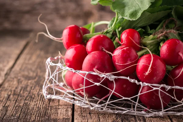 Fresh rustic harvest of radishes healthy vegetables in vintage basket background — Stock Photo, Image
