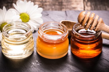 Siyah taş zemin üzerine bal ayı kavanoza tatlım 