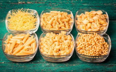 Makarna ahşap rustik arka plan üzerine çeşitli karışımı. Beslenme ve gıda 