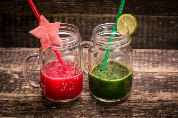 Smoothie vermelho e verde fresco no fundo de madeira vintage. Bebida de desintoxicação saudável — Fotografia de Stock