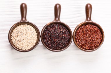 Kırmızı, siyah ve beyaz quinoa tohumları ahşap zemin, sağlıklı gıda.