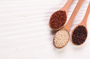 Kırmızı, siyah ve beyaz quinoa tohumları ahşap zemin, sağlıklı gıda.