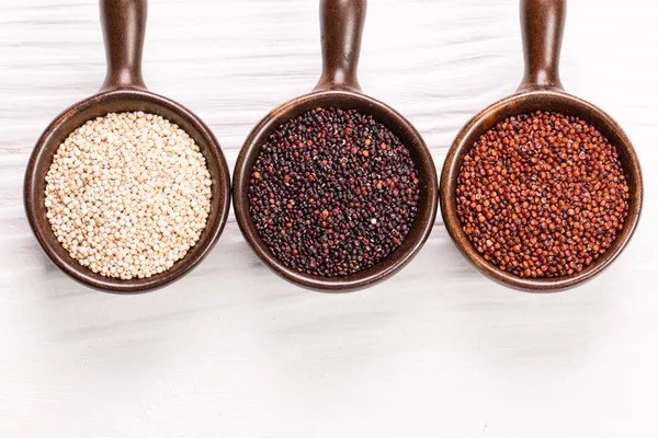 Kırmızı, siyah ve beyaz quinoa tohumları ahşap zemin, sağlıklı gıda.