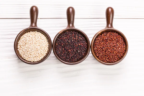 Κόκκινο, μαύρο και άσπρο quinoa σπόροι σε ξύλινα φόντο, υγιεινή διατροφή. — Φωτογραφία Αρχείου