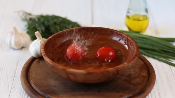 Медленное движение томатов, падающих с капельками воды — стоковое видео