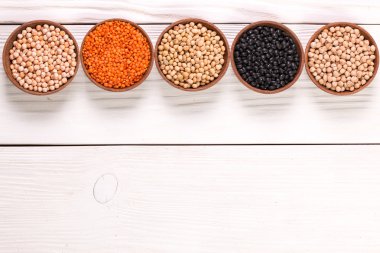 Ahşap arka plan, sağlıklı gıda, vegan gıda çeşitli baklagiller kâse.