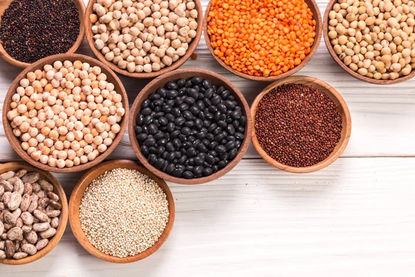 Cuencos de varias legumbres sobre fondo de madera, comida saludable, comida vegana . — Foto de Stock