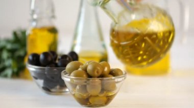 Zeytin ve zeytinyağı dökerek. Sızma zeytinyağı şişeden dökme.