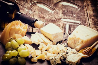 Kompozisyon peynir, çilek, şişe ve bardak şarap ahşap bir masa üzerinde 