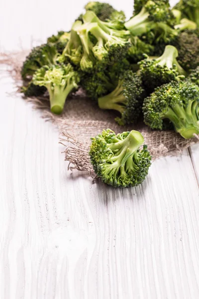 Bunch of fresh green broccoli on brown plate over wooden background — Stock Photo, Image