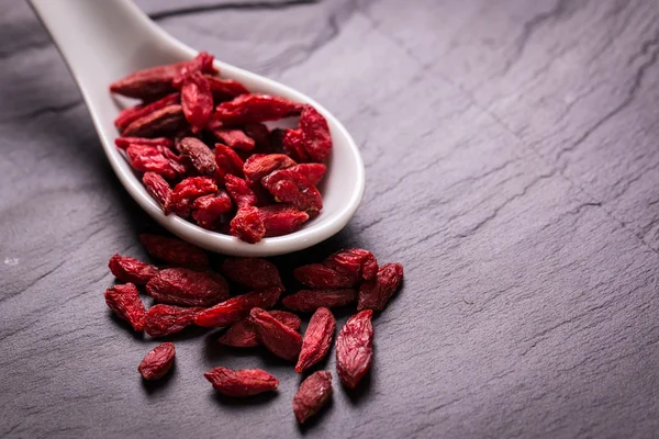 Goji-Beeren, gesundes Superfood, Ernährungskonzept, auf schwarzem Stein — Stockfoto