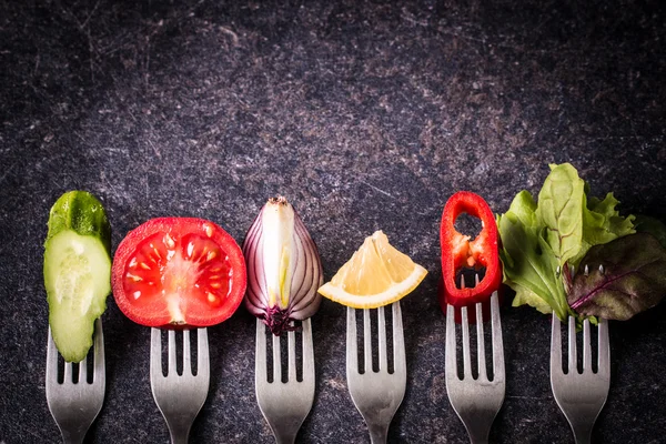 Fresh mixed vegetables on fork on black background — Stock Photo, Image