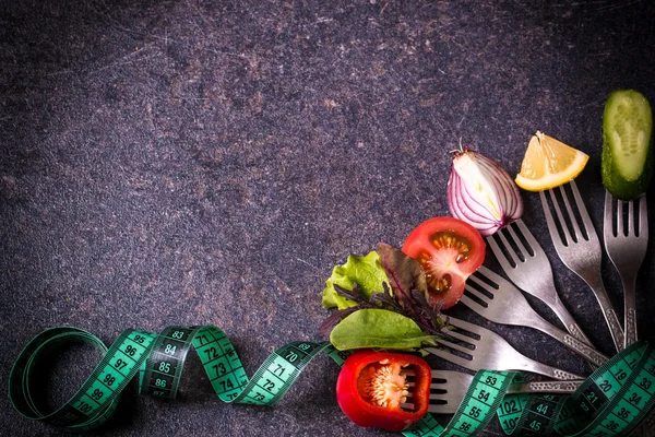 Fresh mixed vegetables on fork on black background