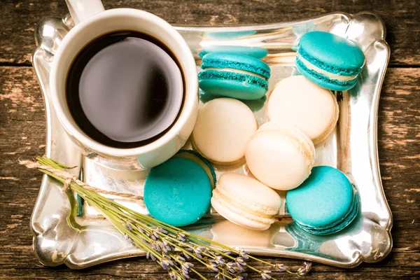 Frische Makronen und Teetasse auf Holztisch .vintage Filter — Stockfoto