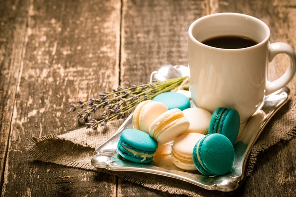 fresh macaroons and tea cup on wooden table .Vintage filter