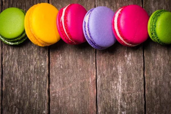 Macaroons frescos na mesa de madeira, filtro vintage — Fotografia de Stock