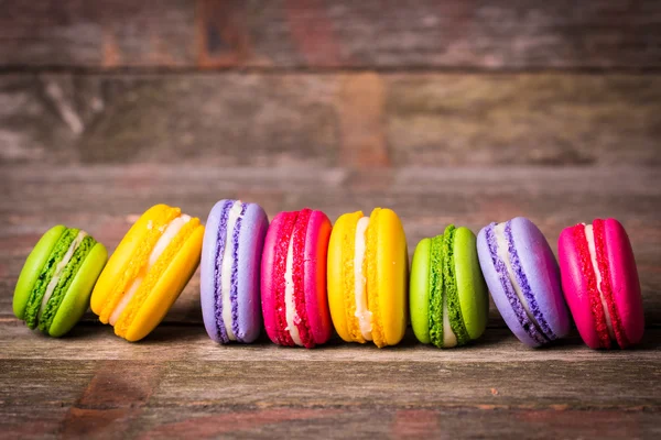 Φρέσκα macaroons σε ξύλινο τραπέζι, εκλεκτής ποιότητας φίλτρο — Φωτογραφία Αρχείου