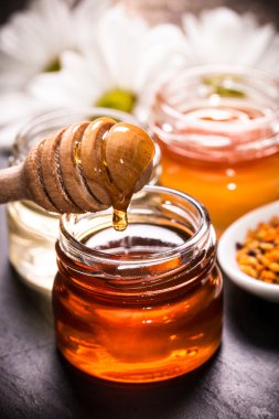 Siyah taş zemin üzerine bal ayı kavanoza tatlım 