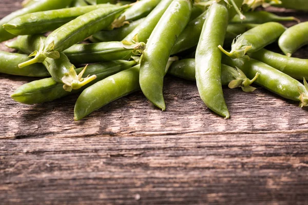 Guisantes verdes en mesa de madera, concepto saludable —  Fotos de Stock