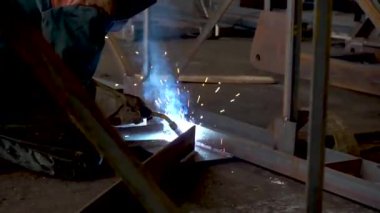 Profesyonel Ağır Sanayi Kaynak İşçisi, Kask Giyiyor ve Kaynak Yapmaya Başlıyor. Petrolün inşaatı. Sanayi İmalat Fabrikası. Dikiş kaynak metalürjisi