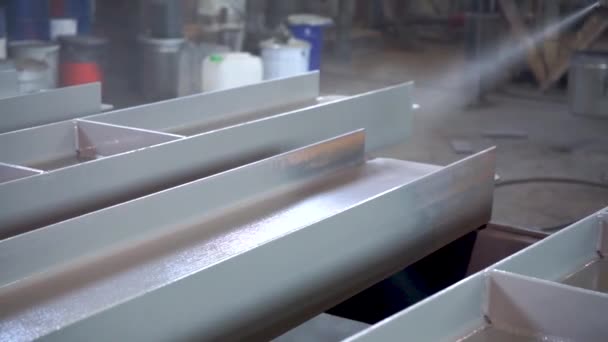 Revestimento em pó de peças metálicas. Trabalhador em terno protetor pulveriza tinta em pó de arma em produtos metálicos — Vídeo de Stock