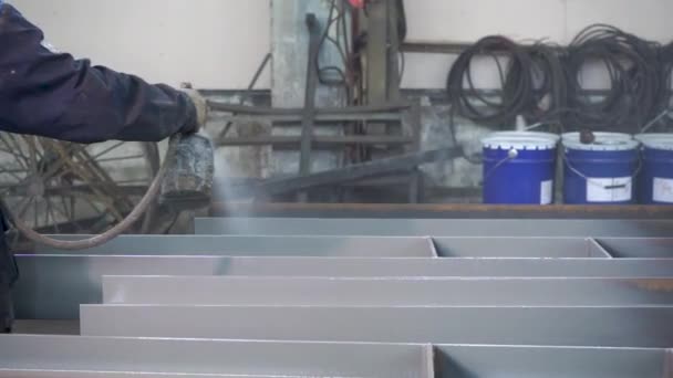 Pulverbeschichtung von Metallteilen. Arbeiter im Schutzanzug sprüht Pulverfarbe aus Pistole auf Metallprodukte — Stockvideo