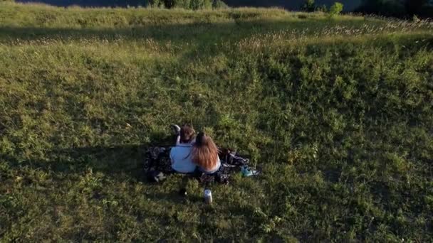 Vue d'en haut sur un jeune couple qui passe du temps ensemble près de l'eau calme. Beau paysage estival d'arbres verts et de mer bleue. Homme et une femme sortir ensemble en plein air. — Video