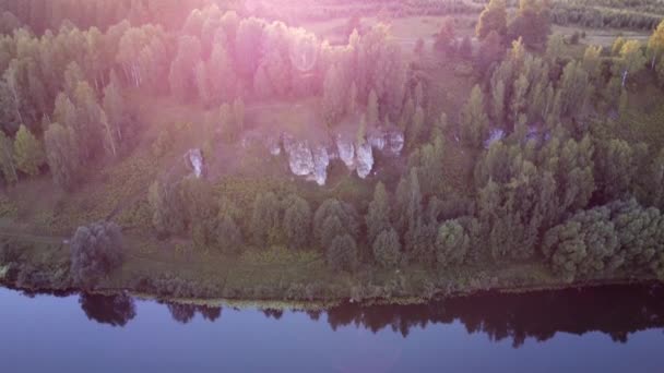4K空中夏早朝日の出品質ビデオ自然のままの緑の松の木の森の映像は、ロシアの小さな町で雲、ダム、島、砂のビーチを反映した穏やかな水、湖に囲まれた — ストック動画