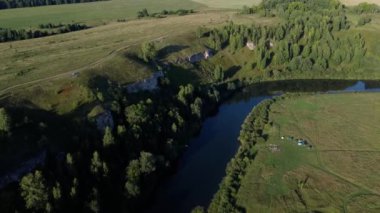 Havadan görünümü: Yeşil ahşap ve güzel nehir üzerine uçuş. Pastel bulutlu gökyüzü günbatımı soft light. Magestic manzara. 4 k çözünürlük.