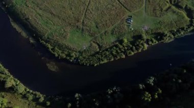 Havadan görünümü: Yeşil ahşap ve güzel nehir üzerine uçuş. Pastel bulutlu gökyüzü günbatımı soft light. Magestic manzara. 4 k çözünürlük.